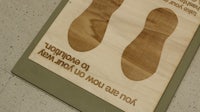 a wooden sign with a pair of shoes on it