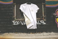 a white t - shirt leaning against a brick wall